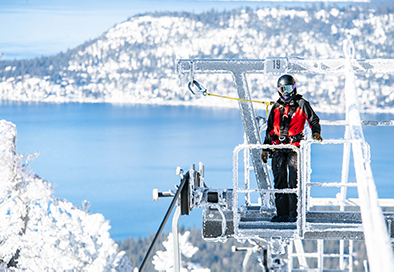 ski patrol director Kari Brandt stands on lift tower overlooking Lake Tahoe